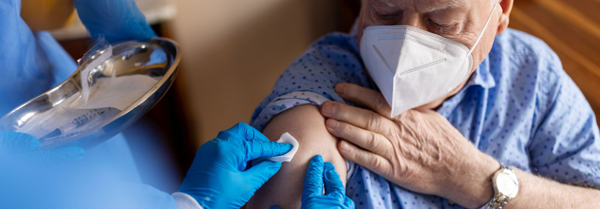 Patient mit FFP Maske bekommt Imfpung
